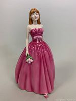 Front view of Royal Doulton porcelain figurine in pink dress holding flowers.