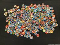 Photo showing a large pile of colorful round baseball buttons with player photos and stats from 1984 Fun Foods.