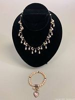 Photo showing choker necklace on display bust and stretchy pearl bracelet below.