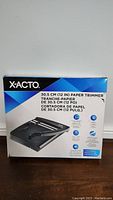 Photo of the X-ACTO 12 inch paper trimmer box showing front of packaging with product image and details in English, French, and Spanish.