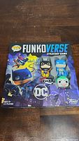 Front view of the Funkoverse Strategy Game box with DC characters on the cover, including Batman, Harley Quinn, and Joker in Funko Pop style.