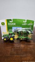 Front view of sealed John Deere 8320R 1/64 scale die-cast tractor with 637 disk implement in original packaging.