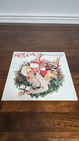 Front cover of Kenny & Dolly Once Upon A Christmas vinyl album showing Kenny Rogers and Dolly Parton with a reindeer and Christmas wreath design