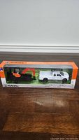 Front view of boxed Kubota KXO40 excavator and Ford pickup truck with trailer diecast models.
