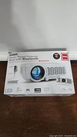 Front of the RCA home theater projector box showing the product image, Bluetooth feature, LED technology, remote control, and branding.