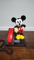Front view of the vintage Disney Mickey Mouse phone showing the full figure and red handset
