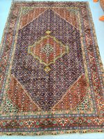 Full view of hand-knotted Persian rug showing overall pattern and condition