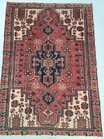 Full view of rug showing red field, navy medallion and decorative border