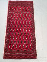 Full view of the rectangular hand knotted wool rug with geometric pattern in deep red and cream tones.