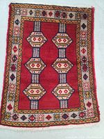 Full view of the rectangular Turkman wool rug showing the central design and border patterns.