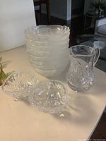 Set of eight frosted glass ice cream bowls stacked, with one crystal water pitcher and two crystal pinwheel candy bowls on the side.