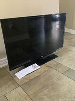Samsung 40-inch flat screen television with quick setup guide placed in front of it.
