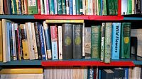 Books on shelf with travel, gardening, history themes, visible titles include Wild Flowers, Germany, and several gardening related books
