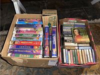 Close-up of Disney VHS tapes stacked horizontally including some titles not fully visible such as Pinocchio and Cinderella