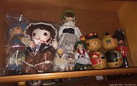 Group photo of fabric and wooden dolls together in a drawer