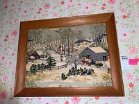 Full view of vintage framed winter landscape art on bark cloth with wooden frame.