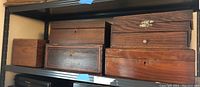 Five wooden boxes placed on shelf in one image, varying sizes and wood finishes visible.