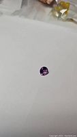 Close-up photo of 2.18ct round diamond cut natural Brazilian amethyst gemstone on white background