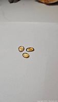 Three natural golden citrine gemstones placed on a white background showing their size and shape.
