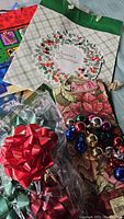 Photo showing holiday and floral gift bags, gift bows, small decorative balls and tissue paper.