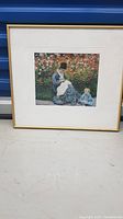 Framed Monet print featuring woman and child in garden scene, full view