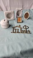 Full view of all items showing four small picture frames, white ceramic trinket box, and brass key holder.