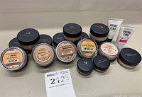 Lot of multiple Bare Minerals loose powder foundation containers in various shades with black lids, and two tubes of Prime Time foundation primer.