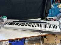 Full view of Casio Privia PX-310 keyboard with standard 88 keys in silver and black on a white surface.