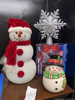 Photo showing the beaded snowman decoration with red scarf and hat, snowflake tree topper, and ceramic snowman cookie jar
