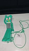 Front view of green Gumby figure shaped phone with keypad and coiled cord.