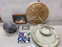 View of entire group of items on table, showing chip and dip plate, wall decor, framed art, glass dish, decorative box, ceramic pig container