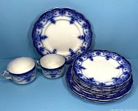Overall photo showing two flow blue cups, a stack of dessert plates, and a single salad plate in the background