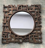 Front view of vintage Coppercraft Guild mirror showing full copper geometric patterned square frame with round mirror center.