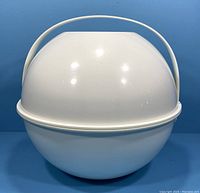 Photo of white spherical picnic set carrying case with handle, closed.