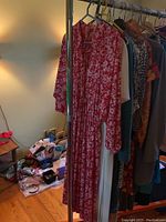 Red long-sleeve floral dress displayed at front on clothing rack