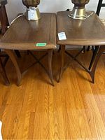 Front view of two wooden end tables side by side on hardwood floor.