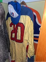 Photo showing yellow and blue vintage hockey jersey #20 with a Toronto baseball cap hung on it.