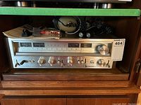 Front view of Pioneer receiver on wood shelf with headphones and microphone on top