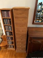 Front view of entire wooden tower next to CD rack and cabinet.