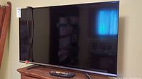 Front view of Haier 42-inch TV with remote control in front.
