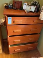 Front view of Vilas maple dresser showing four drawers and wooden handles with various small items on top, contents not included.