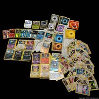 Full view of the Pokémon card assortment showing shinies, energy cards, Pokémon and trainer cards spread out for display.