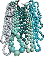 Five turquoise and howlite beaded necklaces laid out side-by-side showing bead variety and condition.