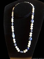 Full view of vintage pearl and Chinese porcelain bead necklace displayed on black bust.