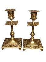 Front and side views of the two antique brass candle holders showing ornate patterned square bases, detailed stems and candle cups.