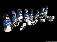 Porcelain Portuguese nativity figures including human figures and animals painted in blue, white, and black with floral designs.