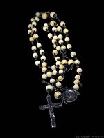 Complete rosary with white beads and sterling silver crucifix shown coiled