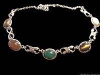 Close-up of the necklace showing the different stones, cabochon cut with bezel silver settings and decorative links.