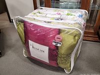 King size Bella Lux comforter set packaged in clear bags showing floral prints and color variety