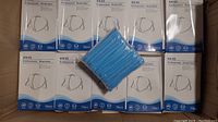 Boxes of KN95 professional respirator masks stacked, each box labeled containing 50 pieces